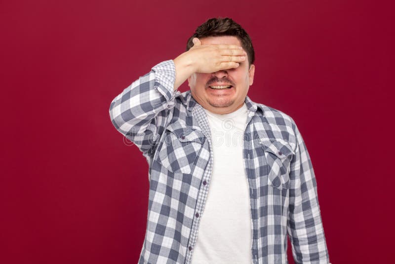 Portrait of shocked handsome middle aged business man in casual checkered shirt standing, closed his eyes with hand and do not royalty free stock images Portrait of shocked handsome middle aged business man in casual checkered shirt standing, closed his eyes with hand and do not royalty free stock images