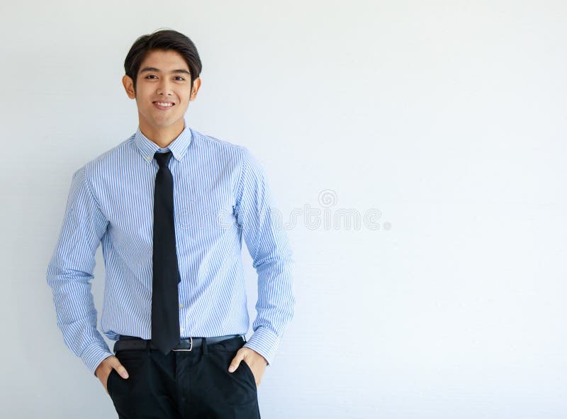 Portrait shot of Asian young happy business office worker wears blue stripe long sleeve shirt standing smiling lean on wall put