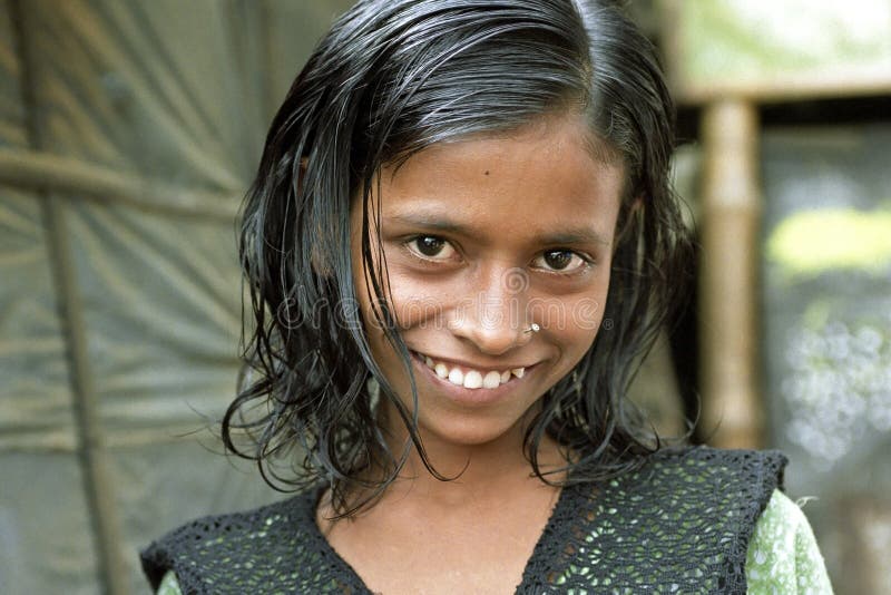 BANGLADESH; city DHAKA: portrait of laughing, beautiful, girl in the slum Mirpur in the capital, city Dhaka. Behind her the hovel where she lives. The shabby housing consists mainly of plastic and bamboo. BANGLADESH; city DHAKA: portrait of laughing, beautiful, girl in the slum Mirpur in the capital, city Dhaka. Behind her the hovel where she lives. The shabby housing consists mainly of plastic and bamboo.