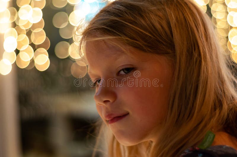 Portrait of a six-year-old girl in profile against the background of lights royalty free stock photo