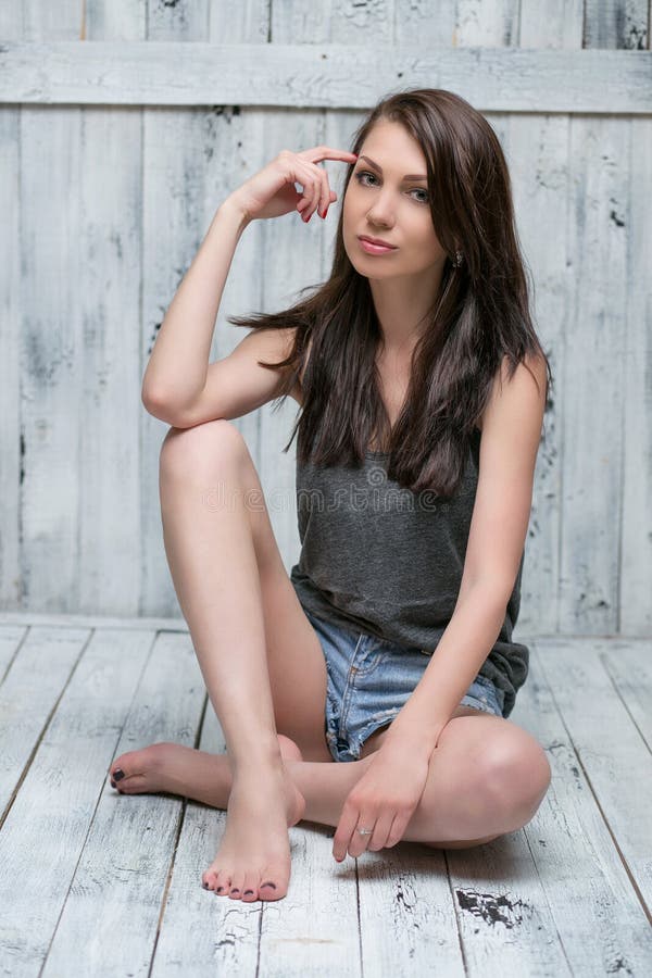 Portrait of a slim attractive girl on the wooden floor