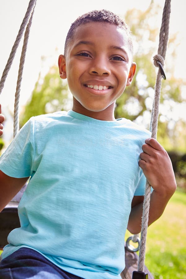 Portrait of Smiling Boy Having Fun Playing on Tire Swing in Garden ...