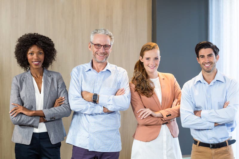 Portrait of Smiling Business People Standing Together with Arms Crossed ...