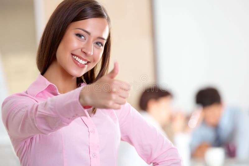 Portrait of smiling business woman with thumbs up gesture