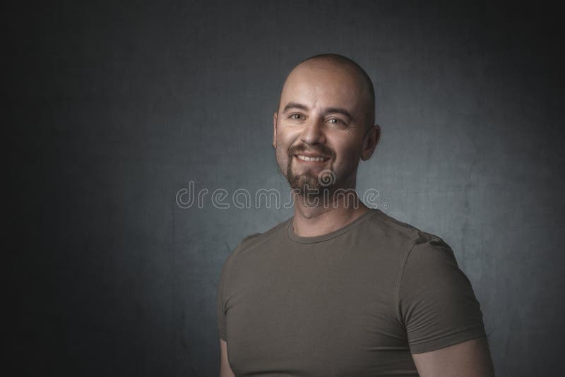 Portrait of smiling caucasian man with t-shirt and dark background stock photo Portrait of smiling caucasian man with t-shirt and dark background stock photo