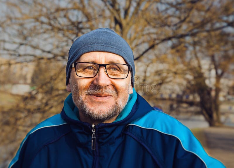 Portrait of a smiling elderly man wearing glasses, a gray hat an royalty free stock images Portrait of a smiling elderly man wearing glasses, a gray hat an royalty free stock images