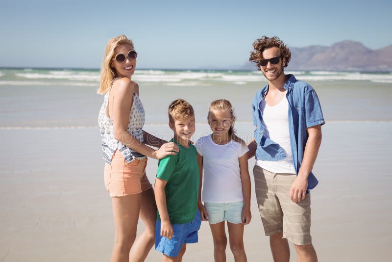 Portrait of smiling family standing at beach stock photos Portrait of smiling family standing at beach stock photos