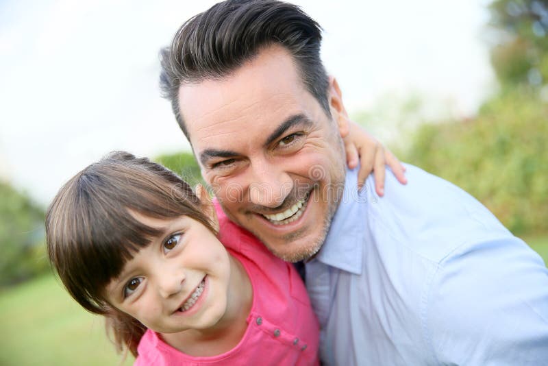 Portrait of smiling father with daughter in his arms stock images Portrait of smiling father with daughter in his arms stock images