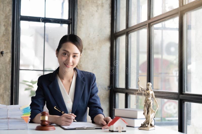 Portrait Smiling Female Lawyer Sitting at Workplace in Office Stock