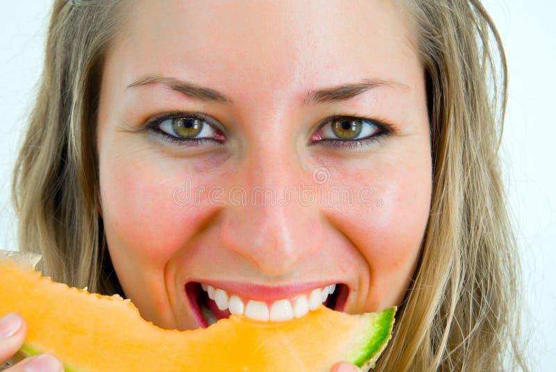 Portrait of a smiling girl eating a melon