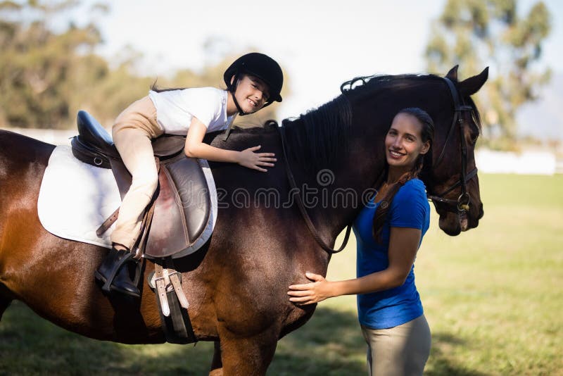 Portrait of smiling jockey and girl embracing horse royalty free stock images Portrait of smiling jockey and girl embracing horse royalty free stock images
