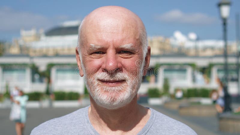 Portrait of smiling man standing outdoors looking at camera. Pensioner traveling in Moscow, Russia