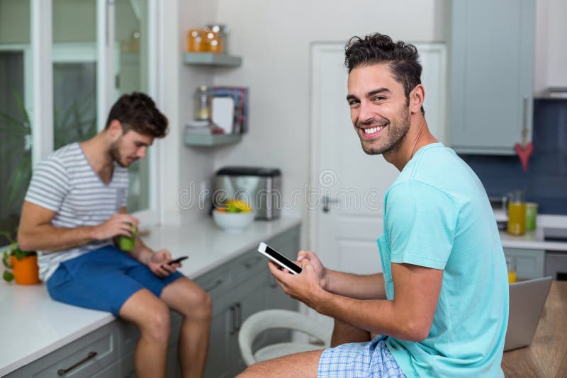 Portrait of smiling man using phone with friend stock photography Portrait of smiling man using phone with friend stock photography