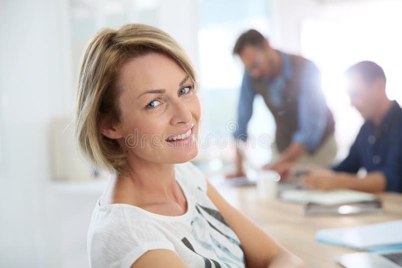 Portrait of smiling office worker amongst colleagues stock image Portrait of smiling office worker amongst colleagues stock image
