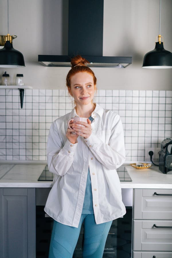 Portrait Of Smiling Redhead Woman Holding Cup Of Hot Beverage In Hands 