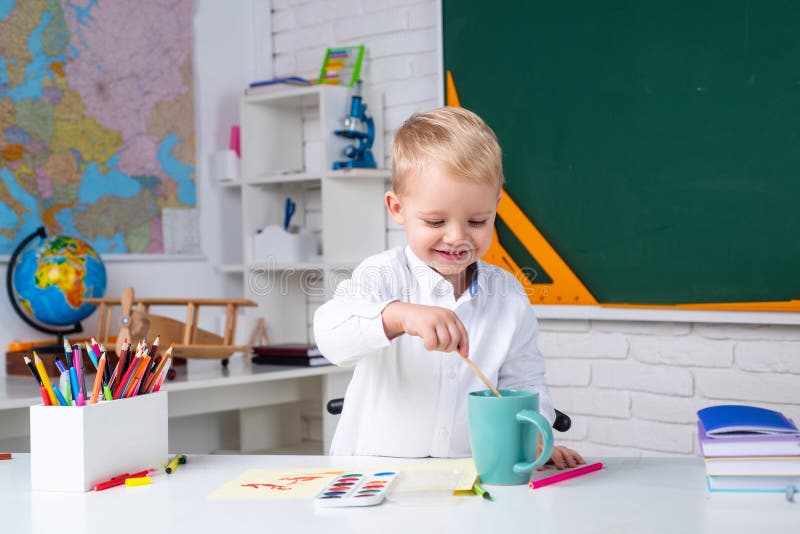 Portrait of smiling schoolboy doing his homework in classroom at school. Education. royalty free stock image