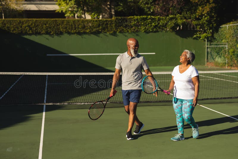 Portrait Of Smiling Senior African American Couple With Tennis Rackets