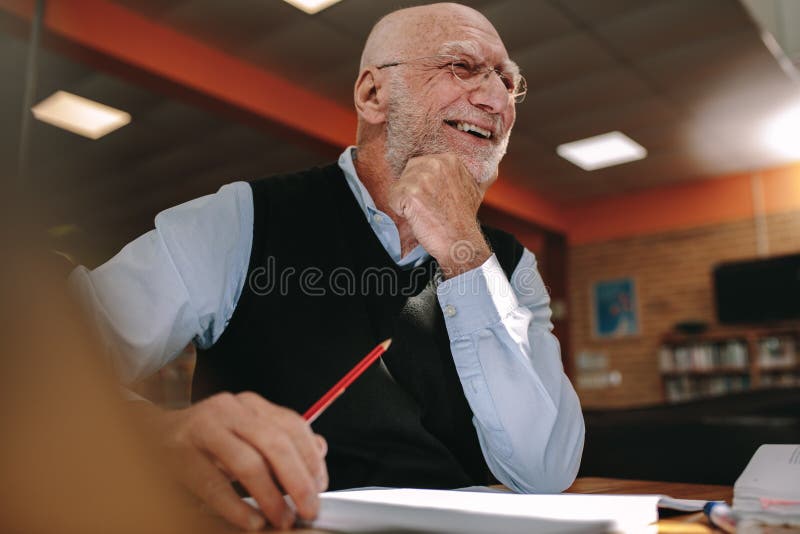 Portrait of a smiling senior man sitting in a library royalty free stock image Portrait of a smiling senior man sitting in a library royalty free stock image