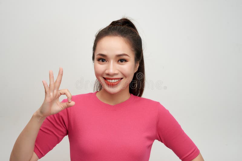 Portrait of a smiling woman showing ok sign with fingers isolated on a white background royalty free stock image Portrait of a smiling woman showing ok sign with fingers isolated on a white background royalty free stock image