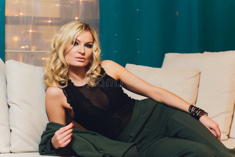 Portrait of smiling woman sitting on sofa. Casual style indoor shoot.