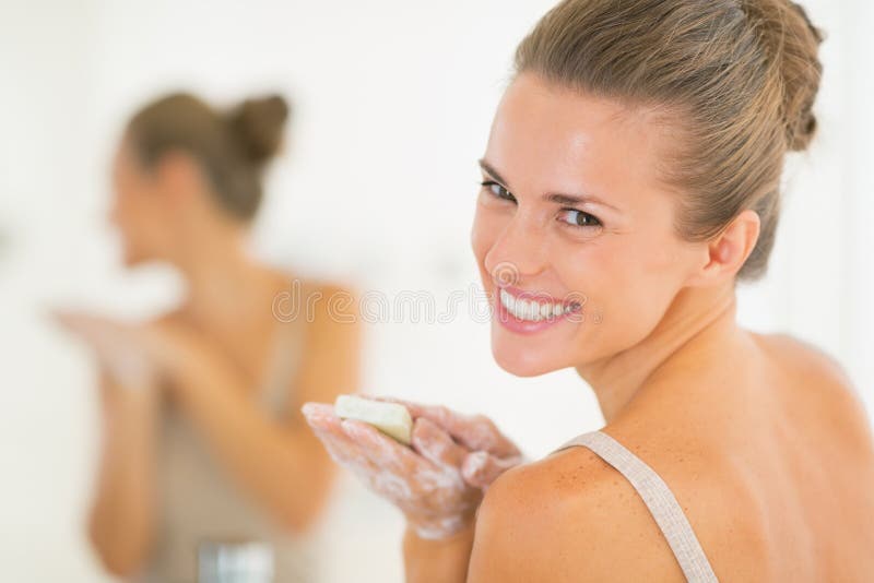 Portrait of smiling woman washing hands with soap royalty free stock photo