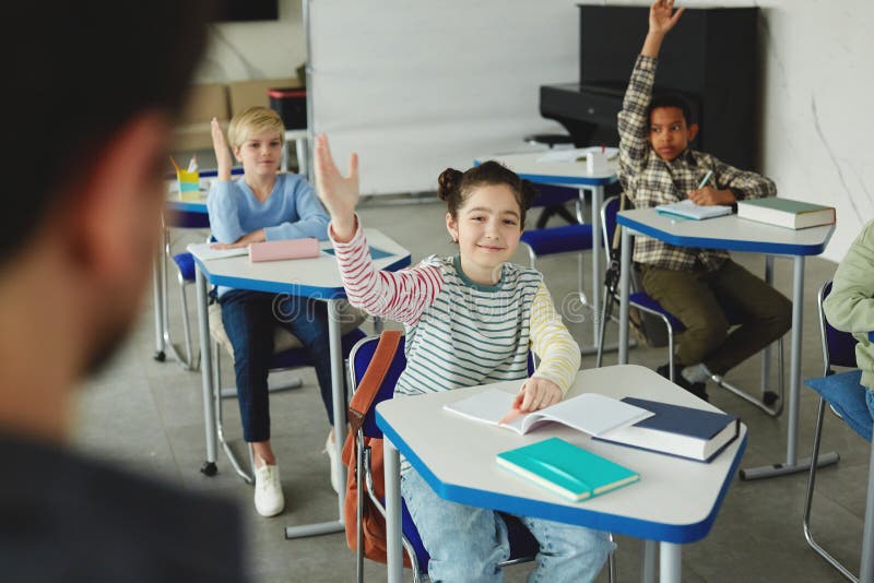 Cute Girl Raising Hand in School stock photography