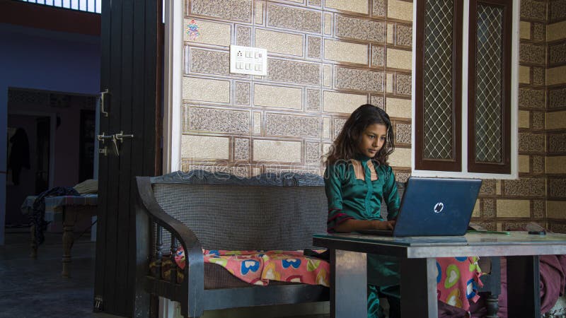Portrait of a Smiling Young Indian Girl Holding Laptop Computer Over Home  Background Stock Photo - Image of attractive, background: 220789806