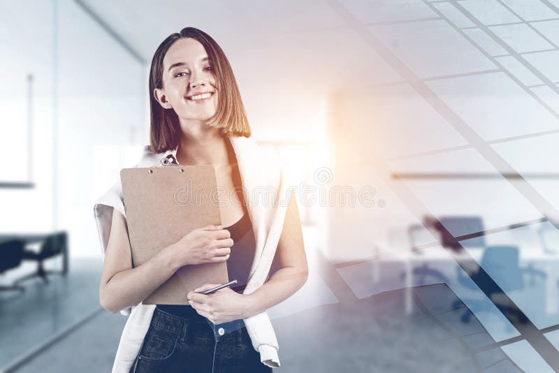 Smiling young woman with clipboard in office stock photography Smiling young woman with clipboard in office stock photography