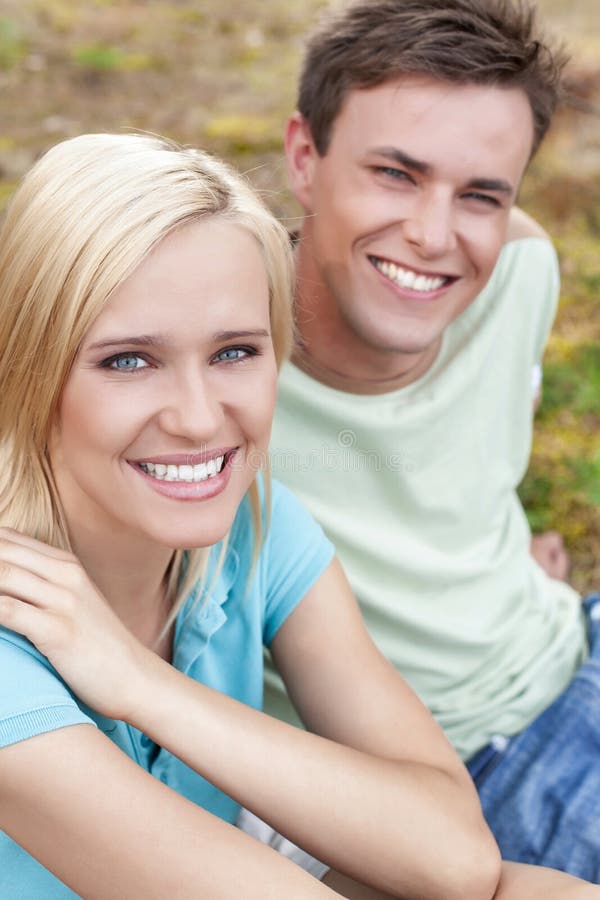Portrait of Smiling Young Woman with Man Relaxing in Park Stock Photo ...