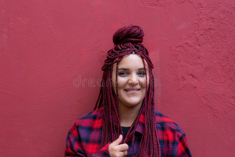 Portrait smiling young woman with red dreadlocks wearing a red checkered shirt