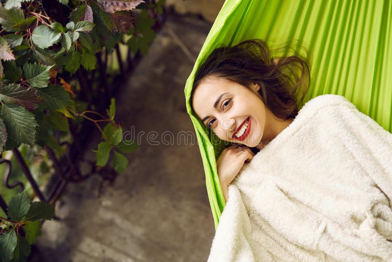 Portrait of smiling young woman relaxing in a hammock on the terrace house. royalty free stock photo Portrait of smiling young woman relaxing in a hammock on the terrace house. royalty free stock photo