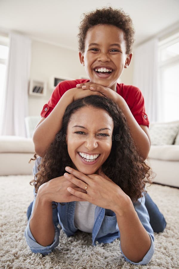 Portrait Of Son Lying On Mothers Back In Lounge royalty free stock photo Portrait Of Son Lying On Mothers Back In Lounge royalty free stock photo