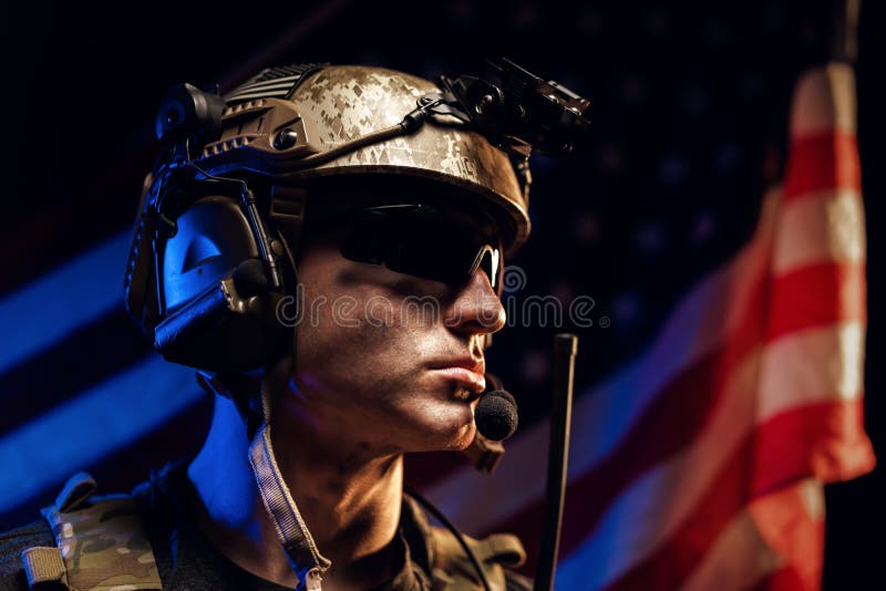 Portrait of special forces soldier in glasses and helmet against US national flag