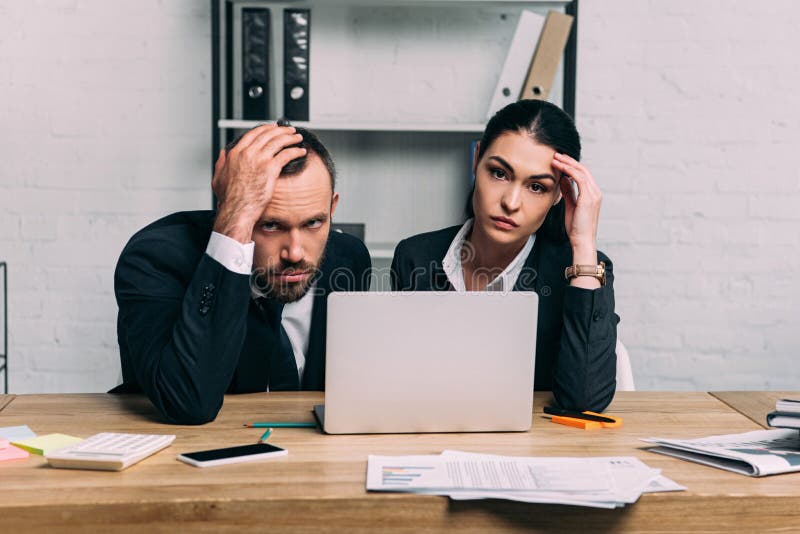 portrait of stressed business people at workplace with documents and laptop stock images portrait of stressed business people at workplace with documents and laptop stock images