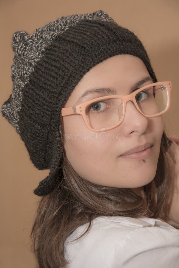 Portrait of stylish girl in knitted hat with funny glasses