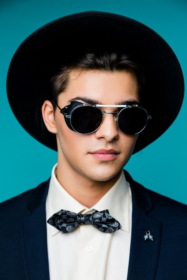 Portrait of a stylish young man in hat wearing elegant suit and sunglasses. royalty free stock photos Portrait of a stylish young man in hat wearing elegant suit and sunglasses. royalty free stock photos