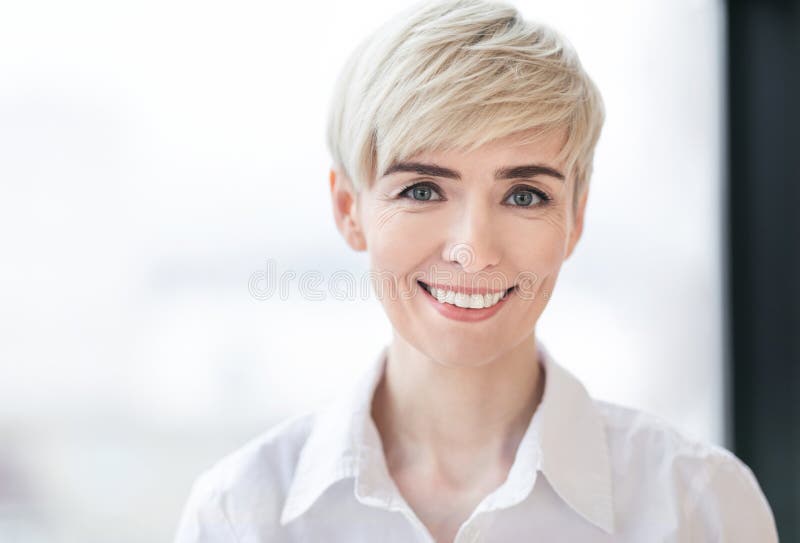 Portrait Of Successful Business Lady Posing Near Window In Office Stock