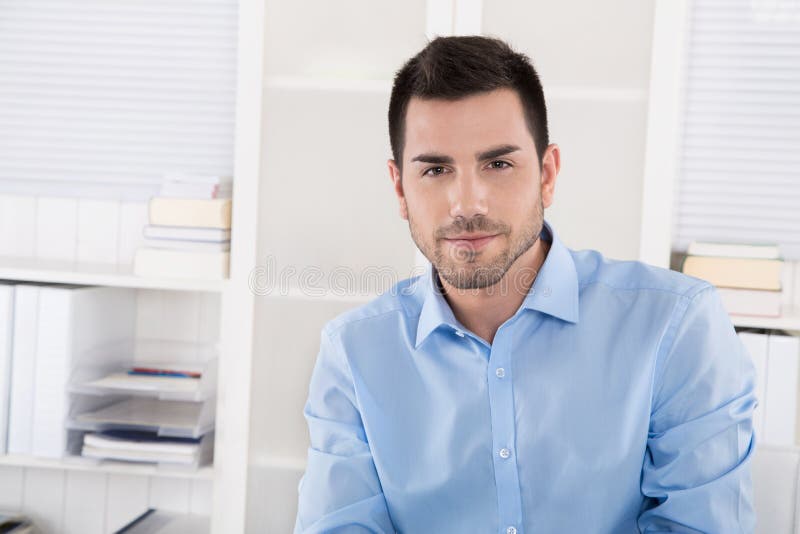 Portrait of a successful businessman in blue shirt sitting in hi