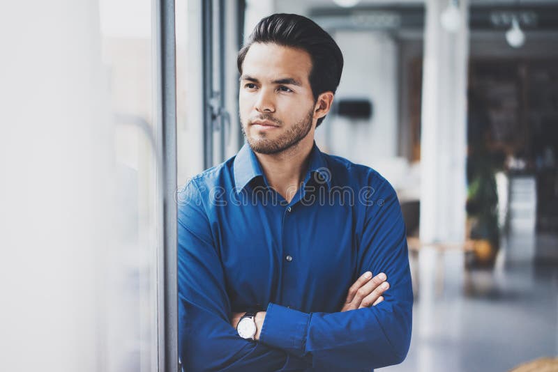 Portrait of successful confident hispanic businessman standing close from the window in modern office.Horizontal,blurred stock images Portrait of successful confident hispanic businessman standing close from the window in modern office.Horizontal,blurred stock images