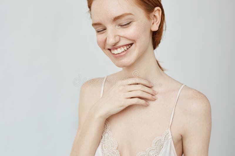 Portrait of tender redhead girl smiling with closed eyes.