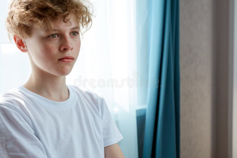 Portrait of thoughtful serious boy with natural red hair