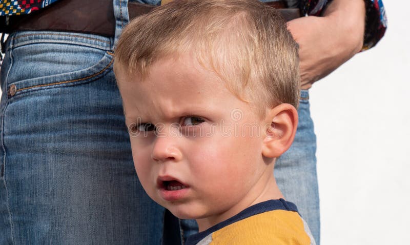 A portrait of toddler boy with angry upset face expression