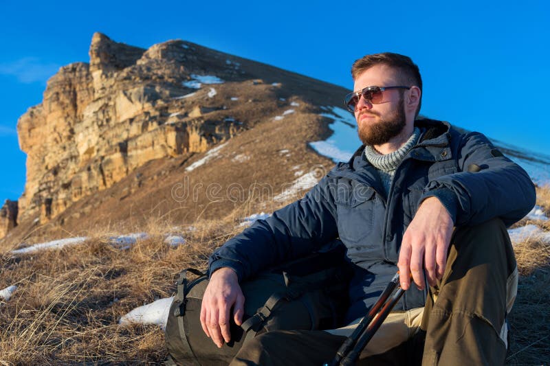 Portrait of tranquil Hipster traveler with beard in sunglasses is sitting on nature. stock images Portrait of tranquil Hipster traveler with beard in sunglasses is sitting on nature. stock images