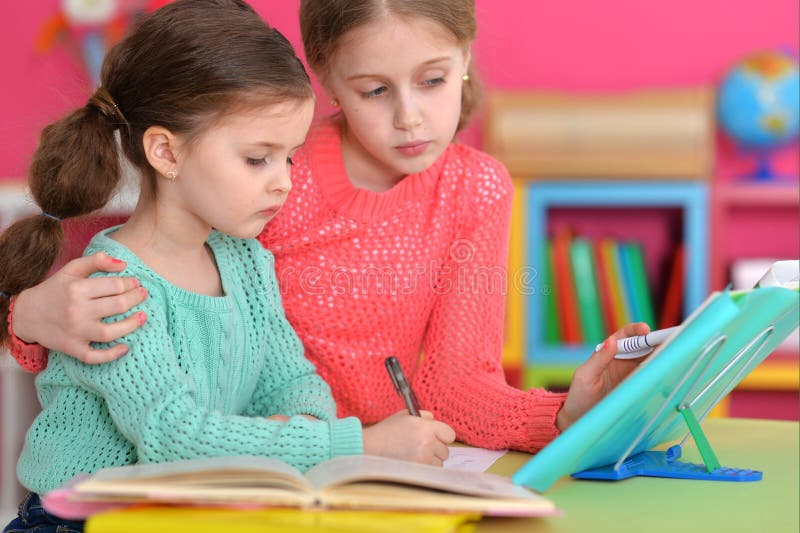 Portrait of two beautiful little girls doping homework royalty free stock images Portrait of two beautiful little girls doping homework royalty free stock images