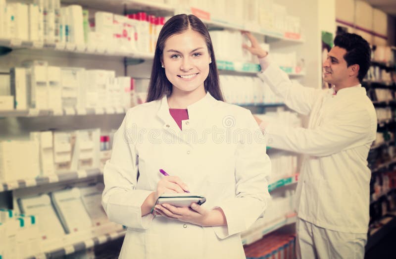 Two happy friendly pharmacists working in modern farmacy. Two happy friendly pharmacists working in modern farmacy