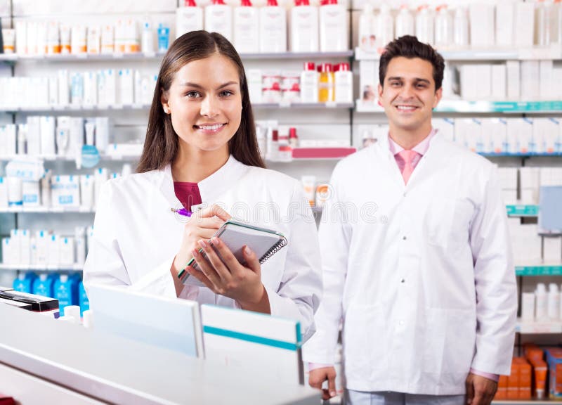 Two positive friendly pharmacists working in modern farmacy. Two positive friendly pharmacists working in modern farmacy