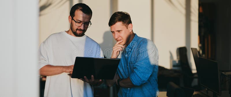 Portrait of two professional male programmers working on computer in diverse offices. Modern IT technologies stock image