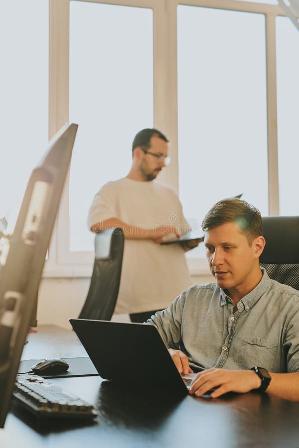 Portrait of two professional male programmers working on computer in diverse offices. Modern IT technologies, development of artificial intelligence, programs, applications and video games concept