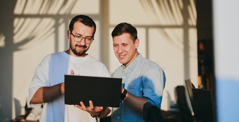Portrait of two professional male programmers working on computer in diverse offices. Modern IT technologies stock photos