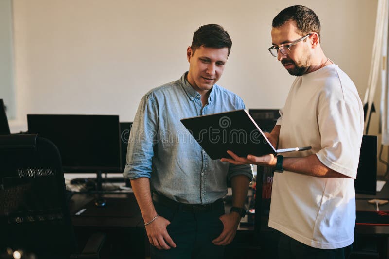 Portrait of two professional male programmers working on computer in diverse offices. Modern IT technologies royalty free stock photo